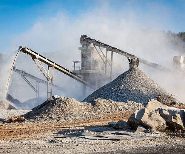 Industrial background - crusher rock stone crushing machine at open pit mining and processing plant for crushed stone, sand and gravel